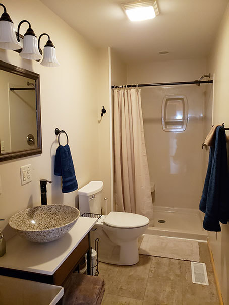 Bathroom showing standing shower, toilet and sink