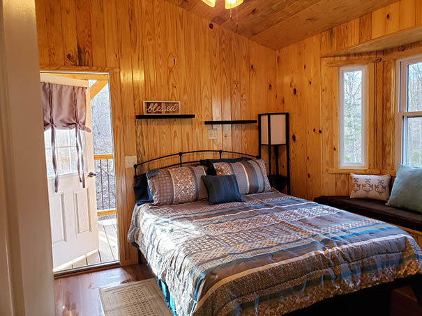 Queen bed  and bay window in the bedroom of the couples cabins