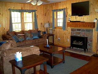 Living room with two couches, tv, and fireplace in Star Falls Resort Cabin