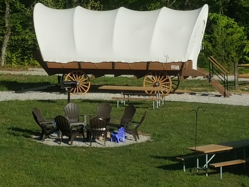Covered Wagon with a central fire ring at Falls Creek Cabins and Campgrounds
